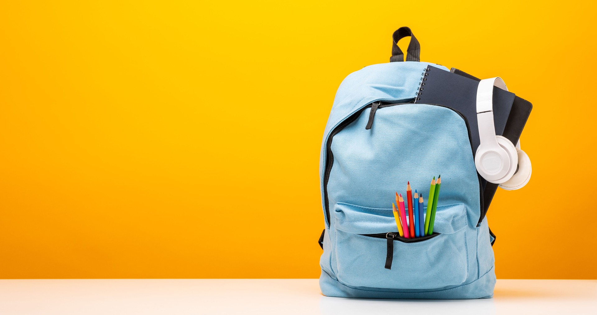 Zurück zur Schule. Schreibwaren in der Schultasche. Banner Design Ausbildung Auf gelbem Hintergrund.